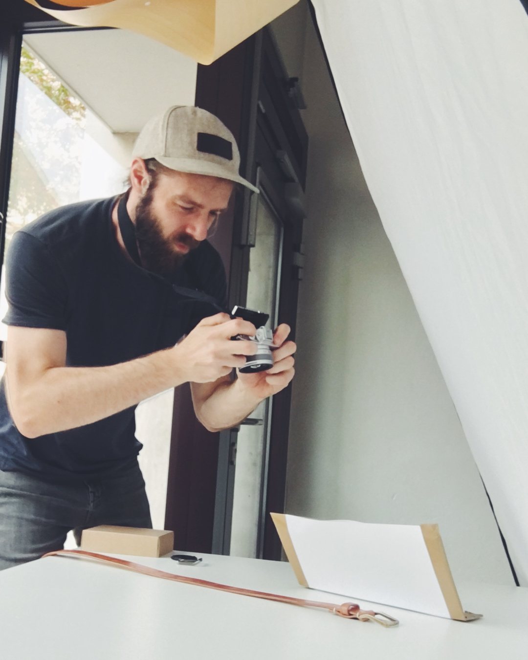 Improvisiertes Fotoset: Ein Gürtel liegt vor weißem Karton und wird fotografiert